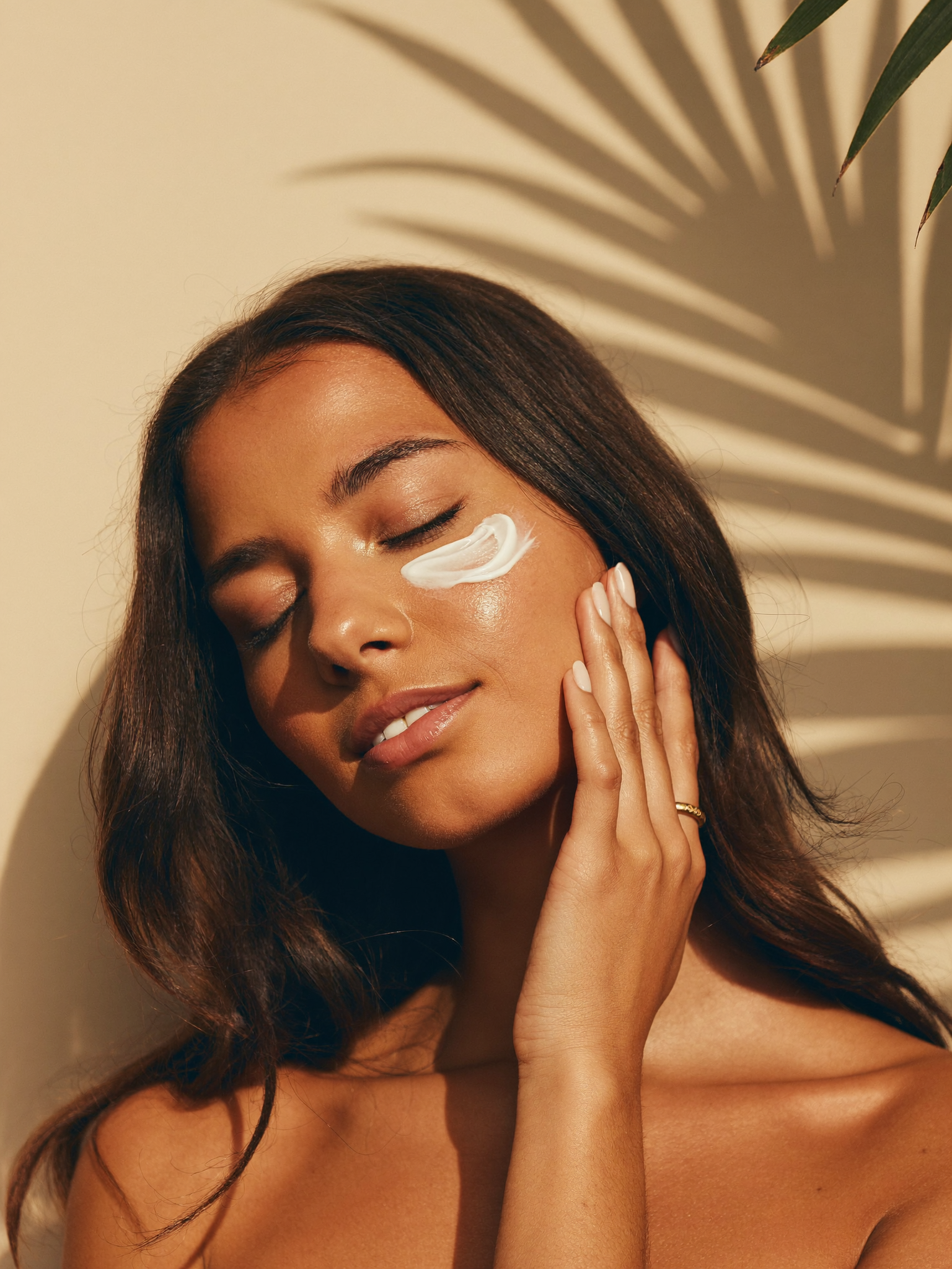 Woman with caramel skin applying the Velvet Creme cream